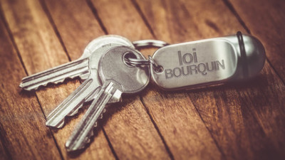 Clés accrochées à un porte-clés sur lequel est écrit « loi Bourquin »